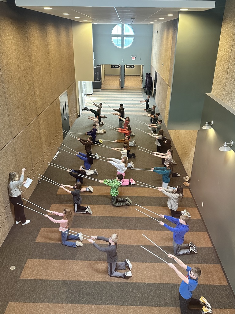 sixth grade students holding white rods which they use in a choreographed song