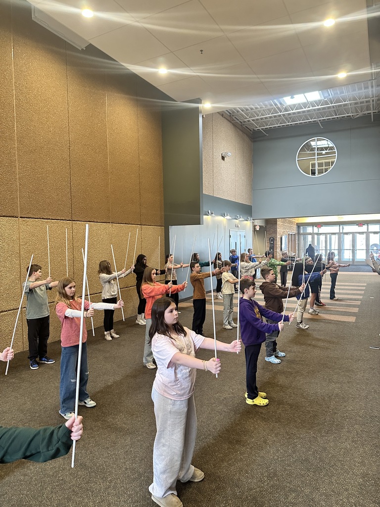 sixth grade students holding white rods which they use in a choreographed song