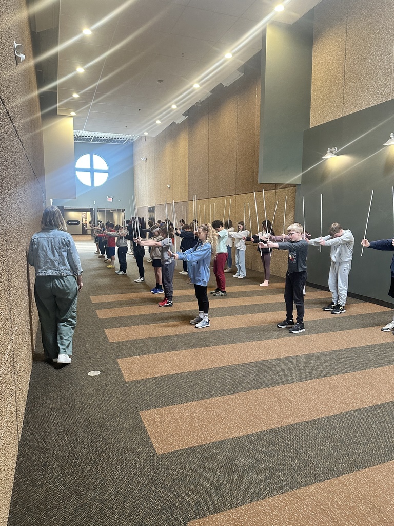 sixth grade students holding white rods which they use in a choreographed song