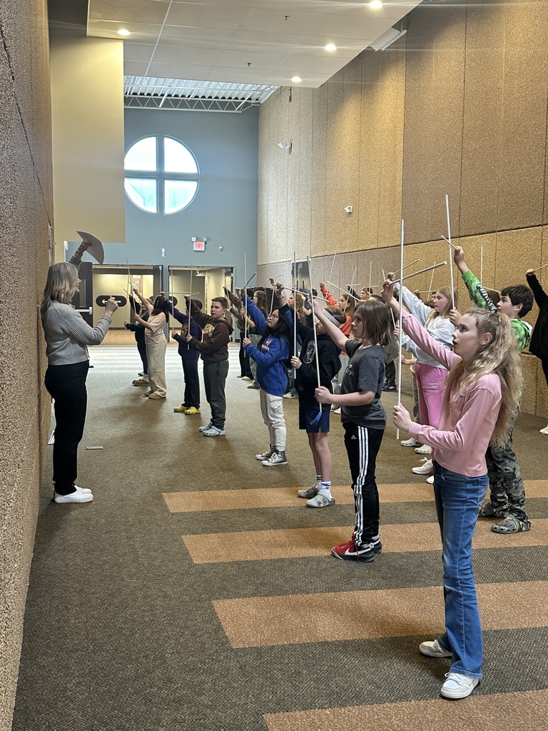 sixth grade students holding white rods which they use in a choreographed song