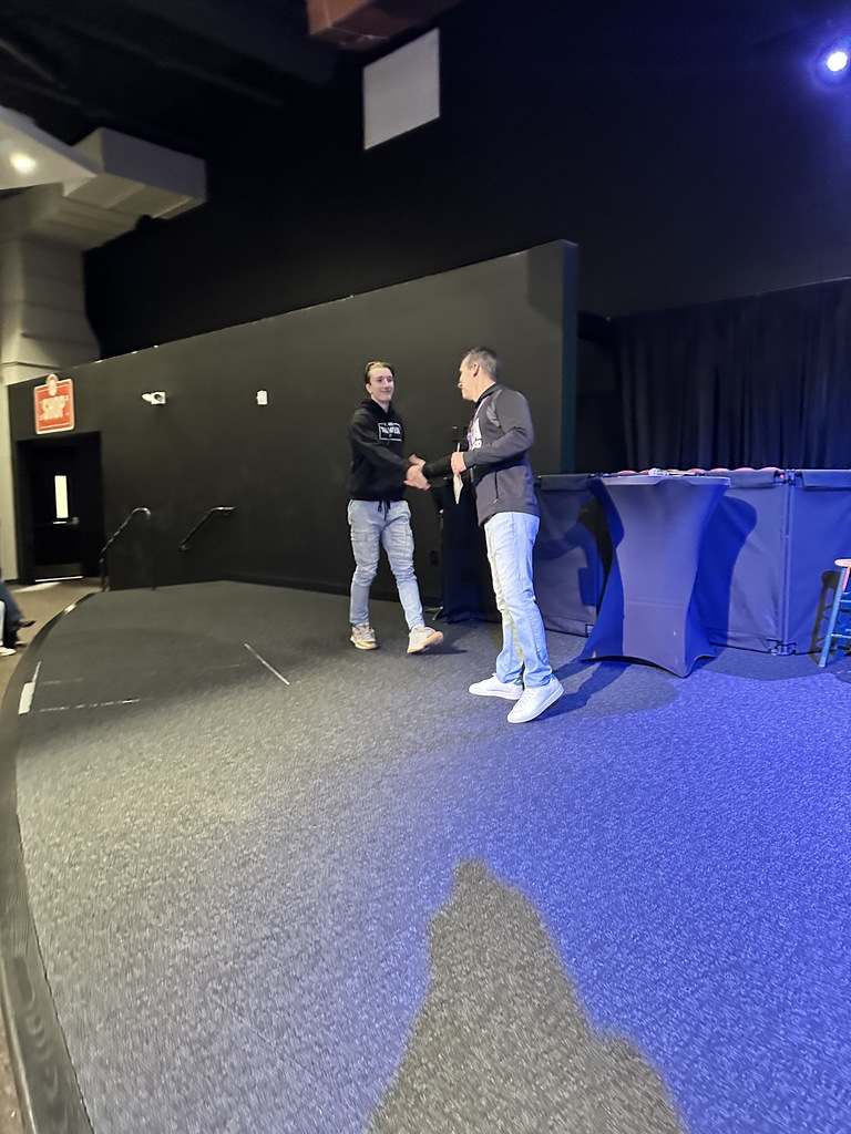 high school teacher handing a certificate to a student