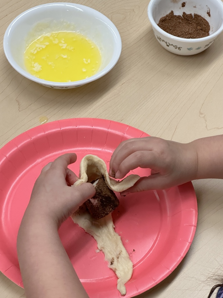 pre-k hands shown rolling dough around a marshmallow