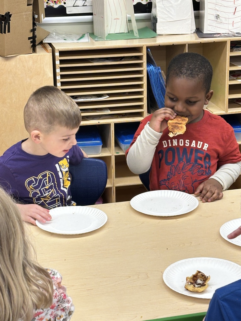pre-k students eating their empty tomb rolls