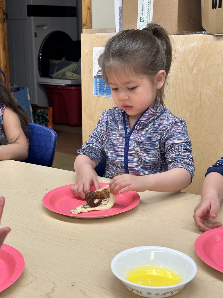 Pre-k students working with dough and marshmallows to make empty tomb rolls