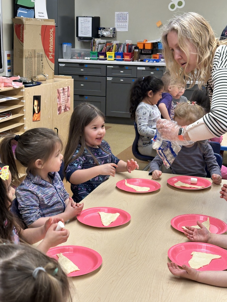 Pre-k students working with dough and marshmallows to make empty tomb rolls