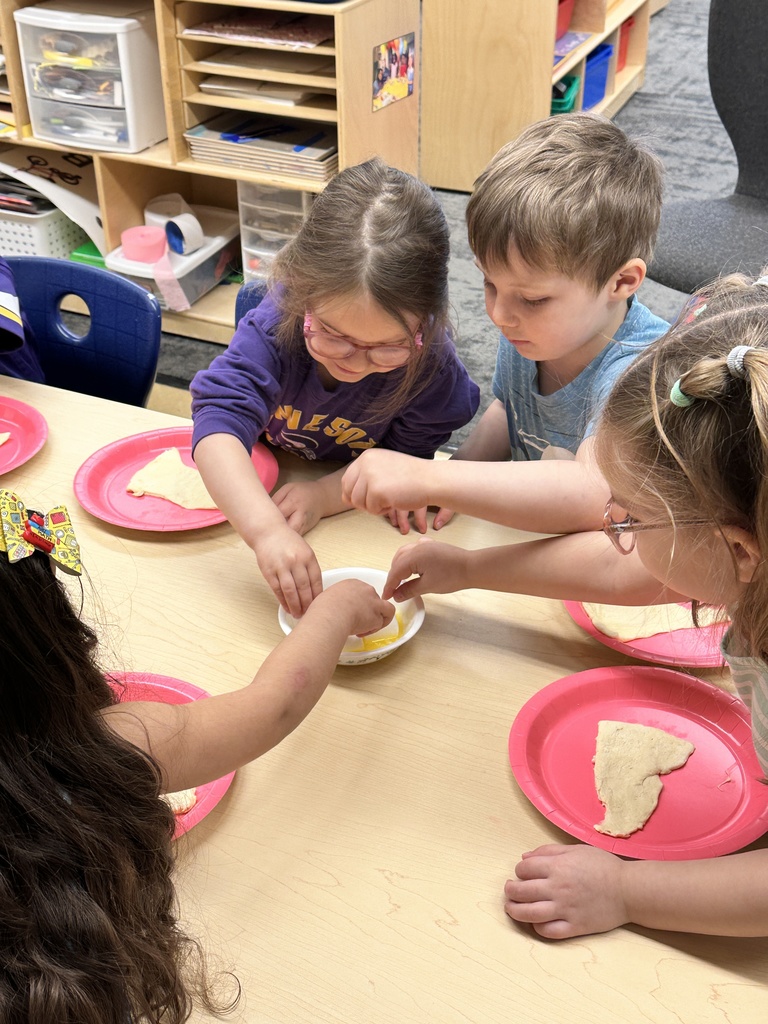 Pre-k students working with dough and marshmallows to make empty tomb rolls