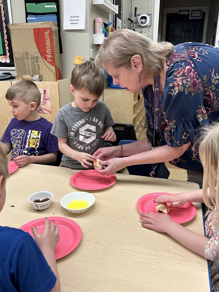 Pre-k students working with dough and marshmallows to make empty tomb rolls