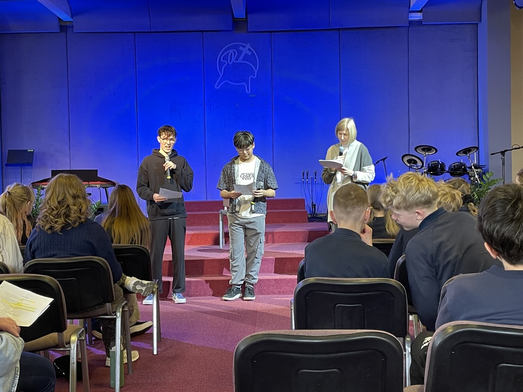 students speaking in front of a church