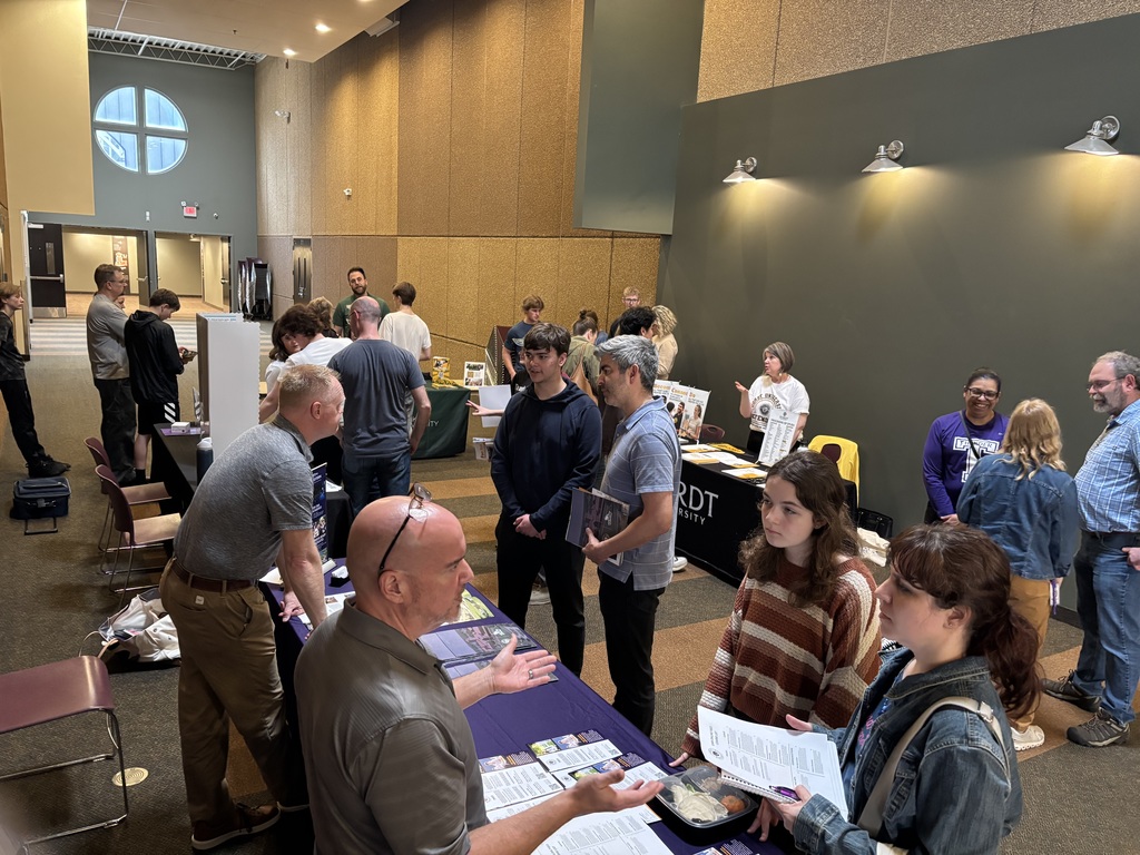 students and parents speaking to college representatives