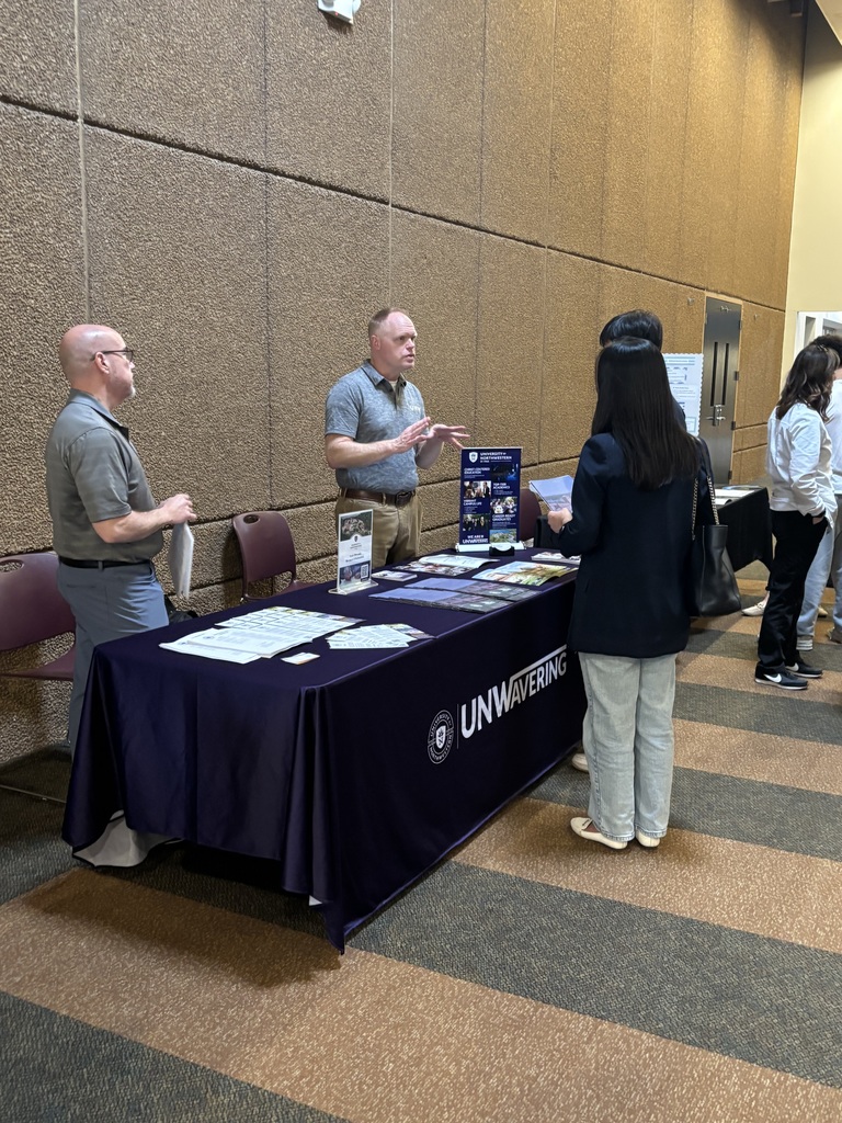 students and parents speaking to college representatives