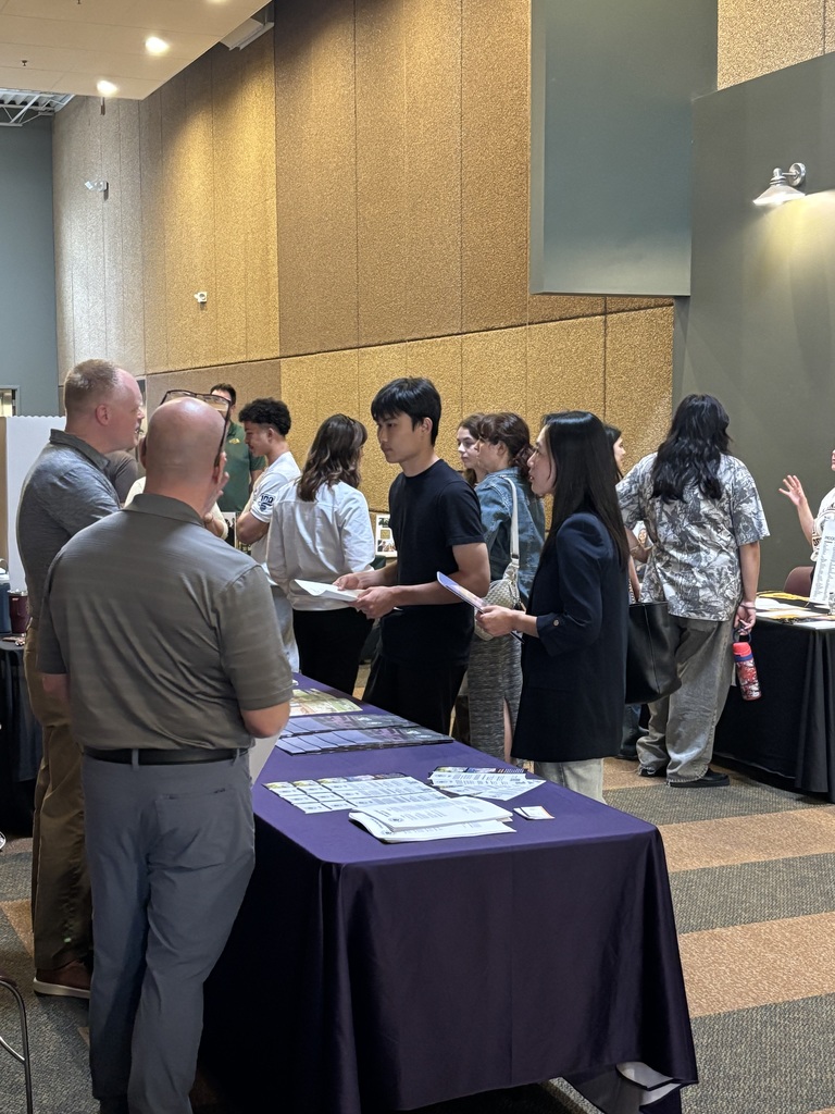 students and parents speaking to college representatives