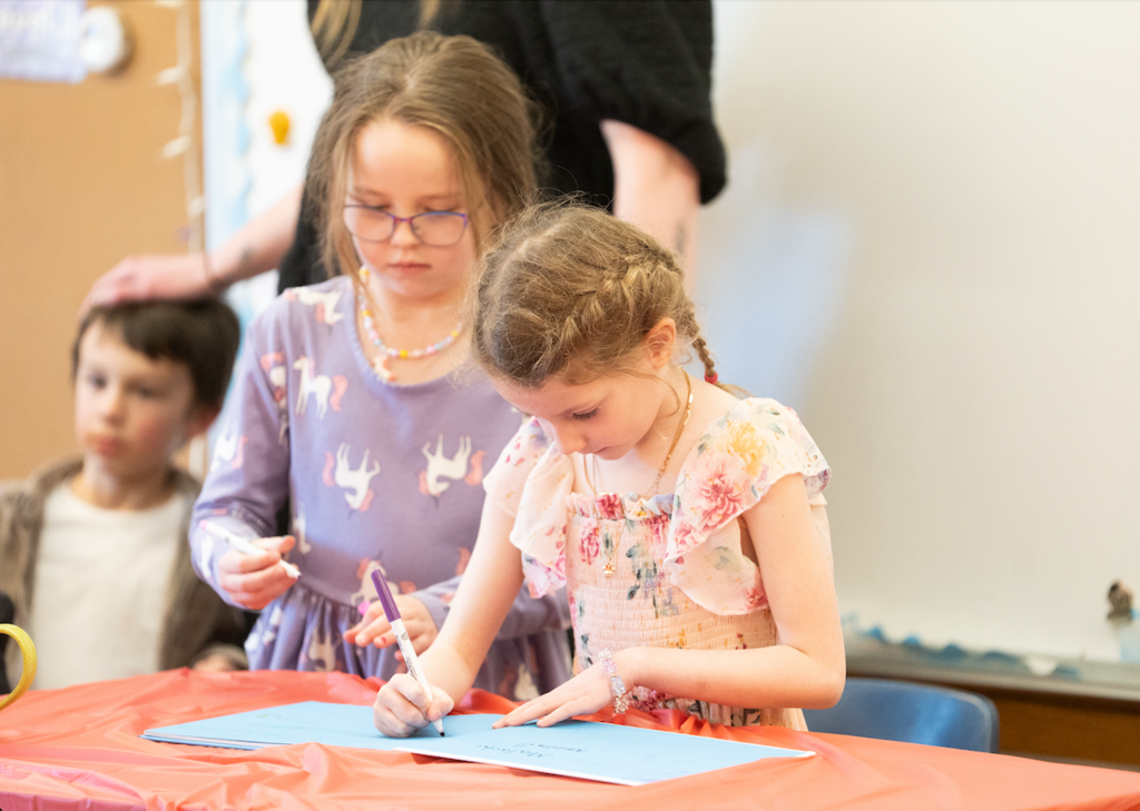 two students signing the book that they published