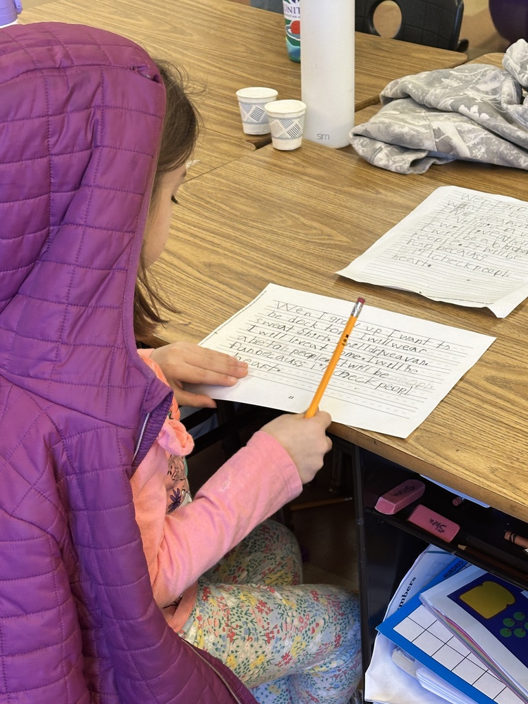 student sitting at her desk writing a story