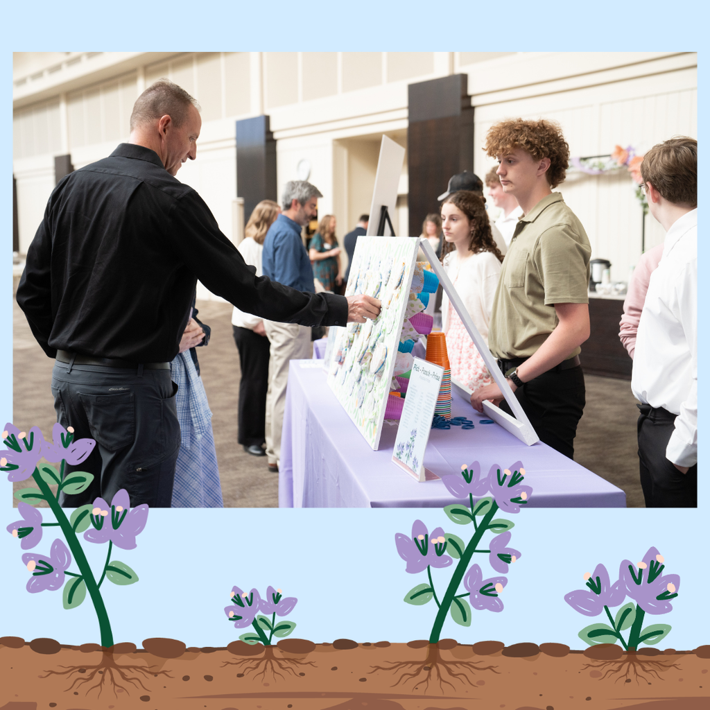 students working at a raffle table and guests buying tickets