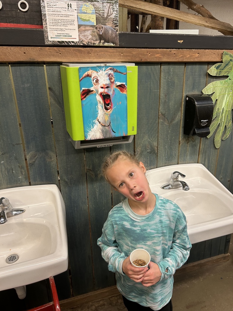 student making a silly face that matches the poster behind her