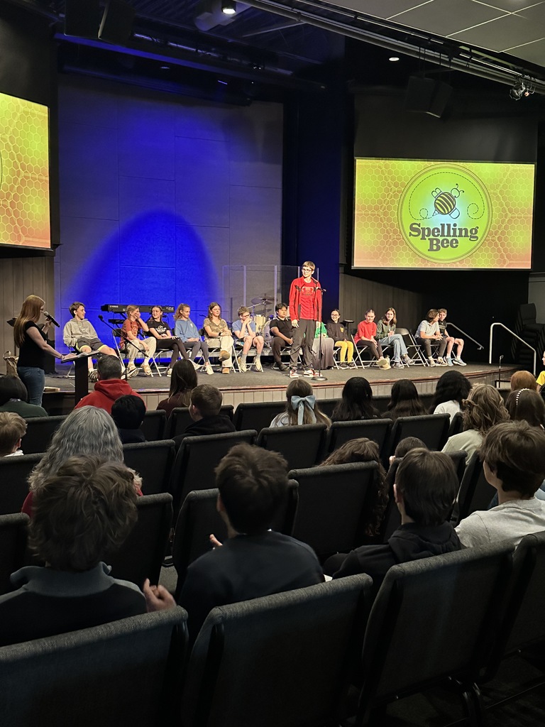 middle school student standing at a microphone during a spelling bee