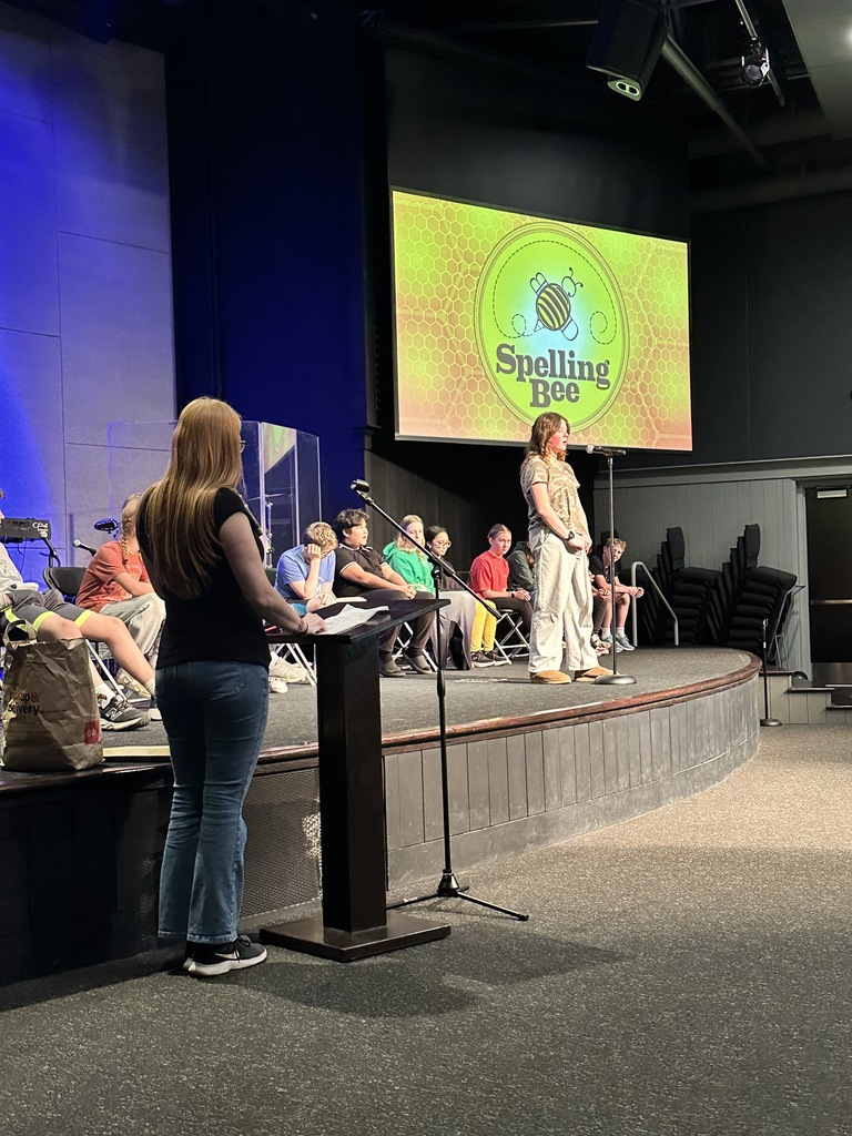 middle school student standing at a microphone during a spelling bee