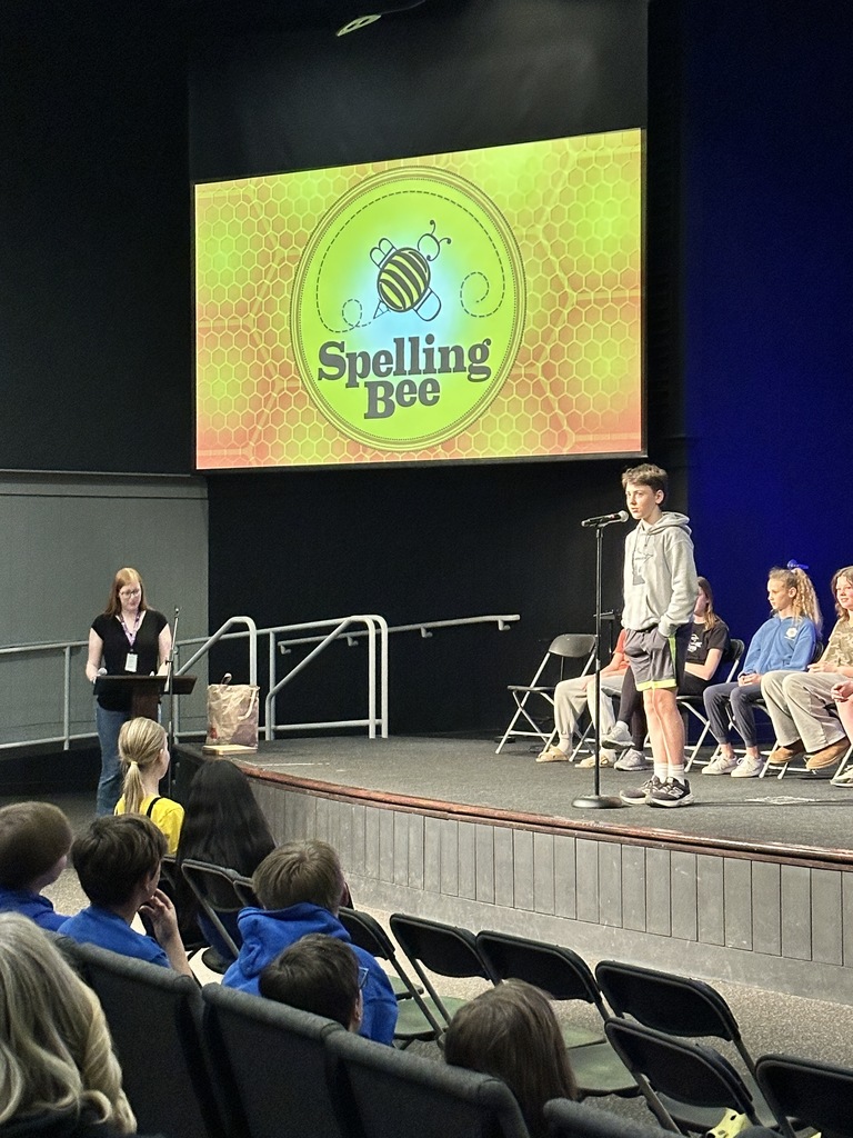 middle school student standing at a microphone during a spelling bee