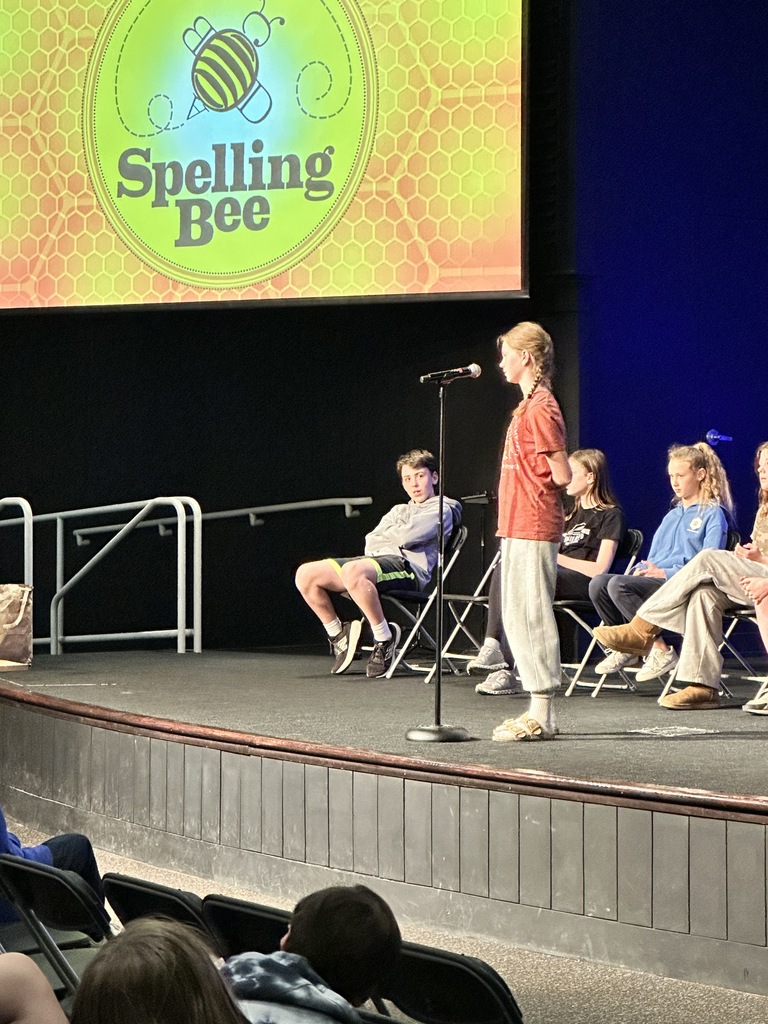 middle school student standing at a microphone during a spelling bee