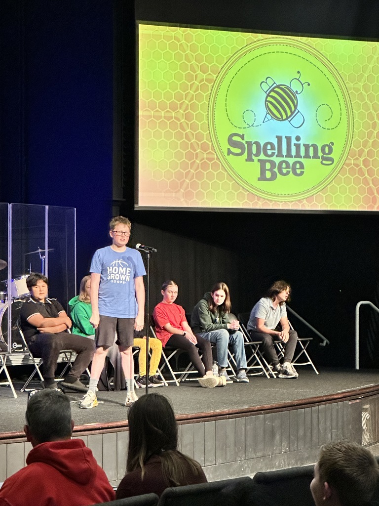 middle school student standing at a microphone during a spelling bee