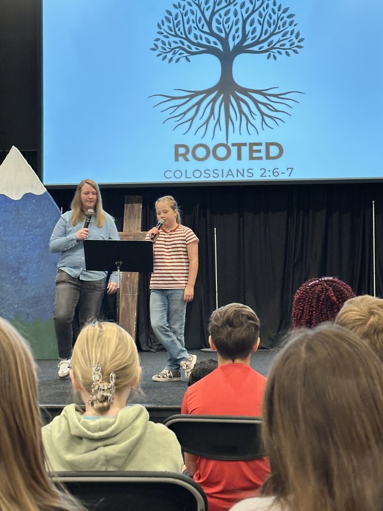 student and pastor speaking on stage during chapel