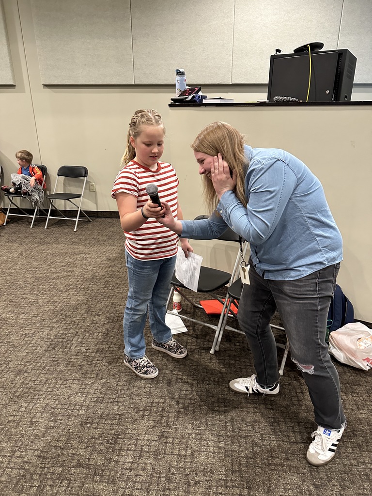 teacher showing a student how to work a microphone