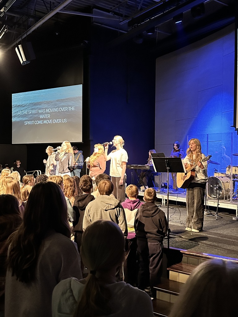 students singing on stage, leading worship