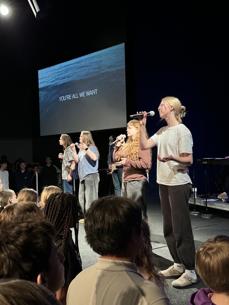students singing on stage, leading worship