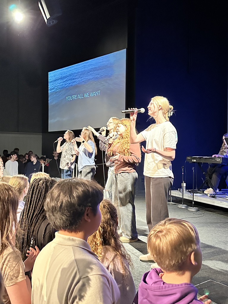 students singing on stage, leading worship