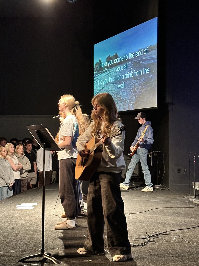 students singing on stage, leading worship