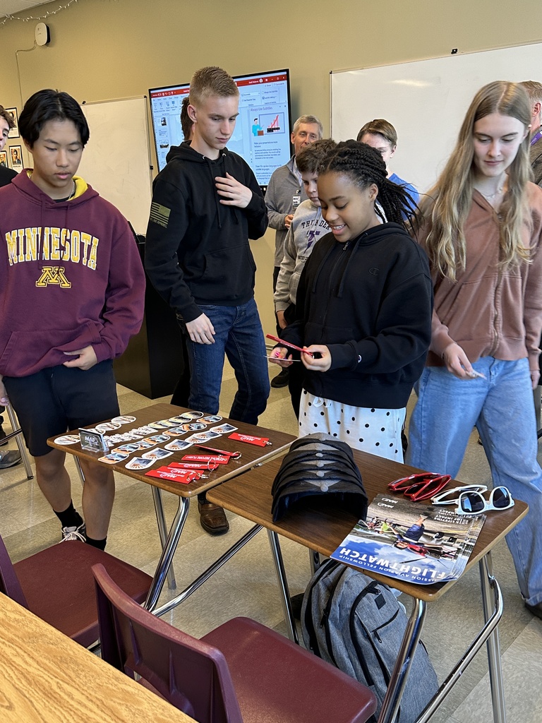 students looking at swag options laid out on a desk