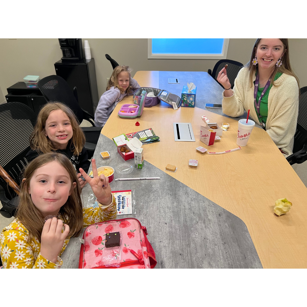 students eating lunch with a teacher