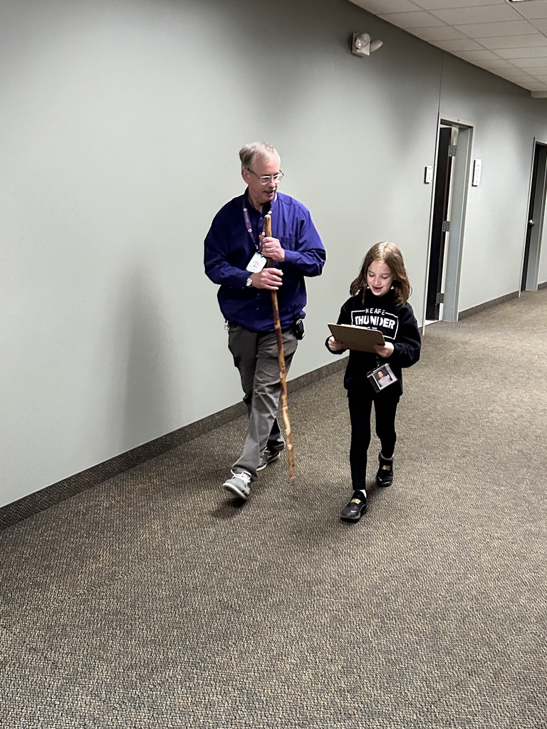 student and principal walking in the hallway