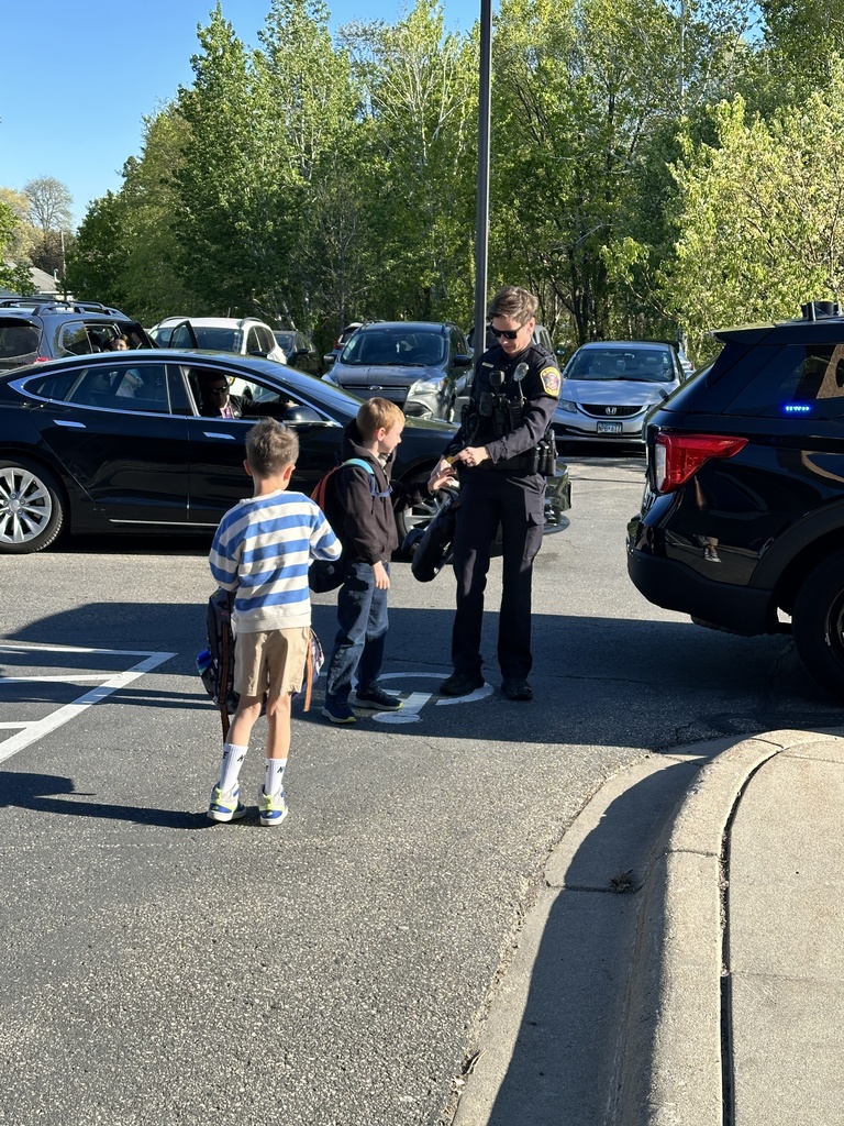 student and a police officer standing outside the school