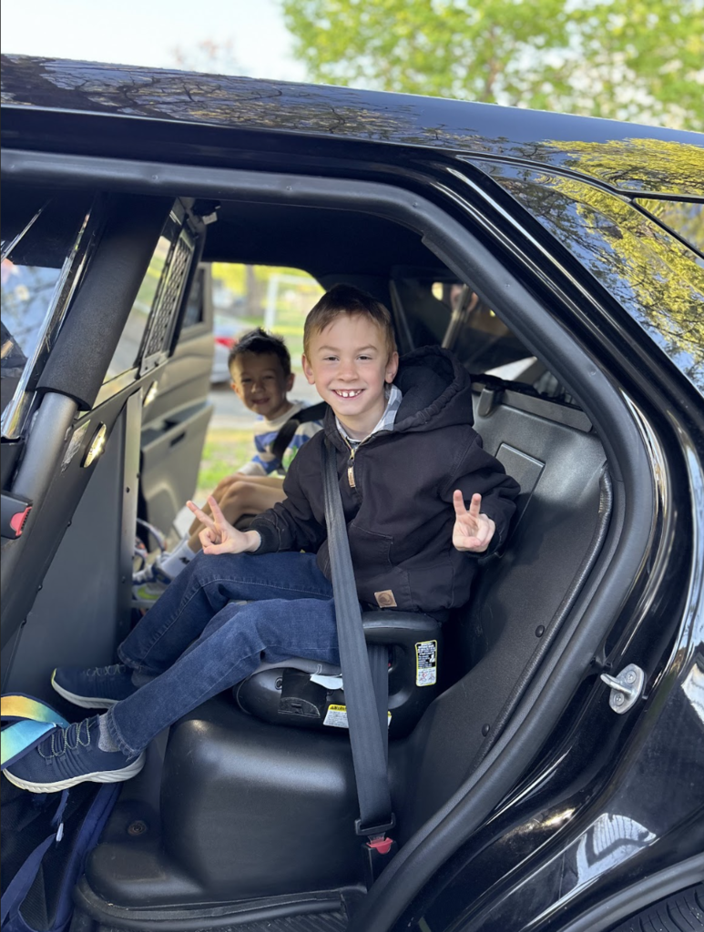 two students inside a police car