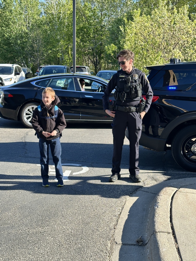 student and a police officer standing outside the school