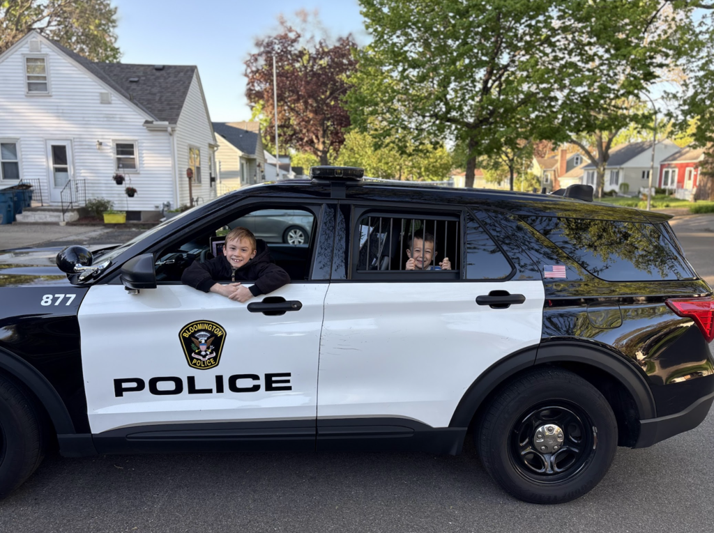 two students inside a police car