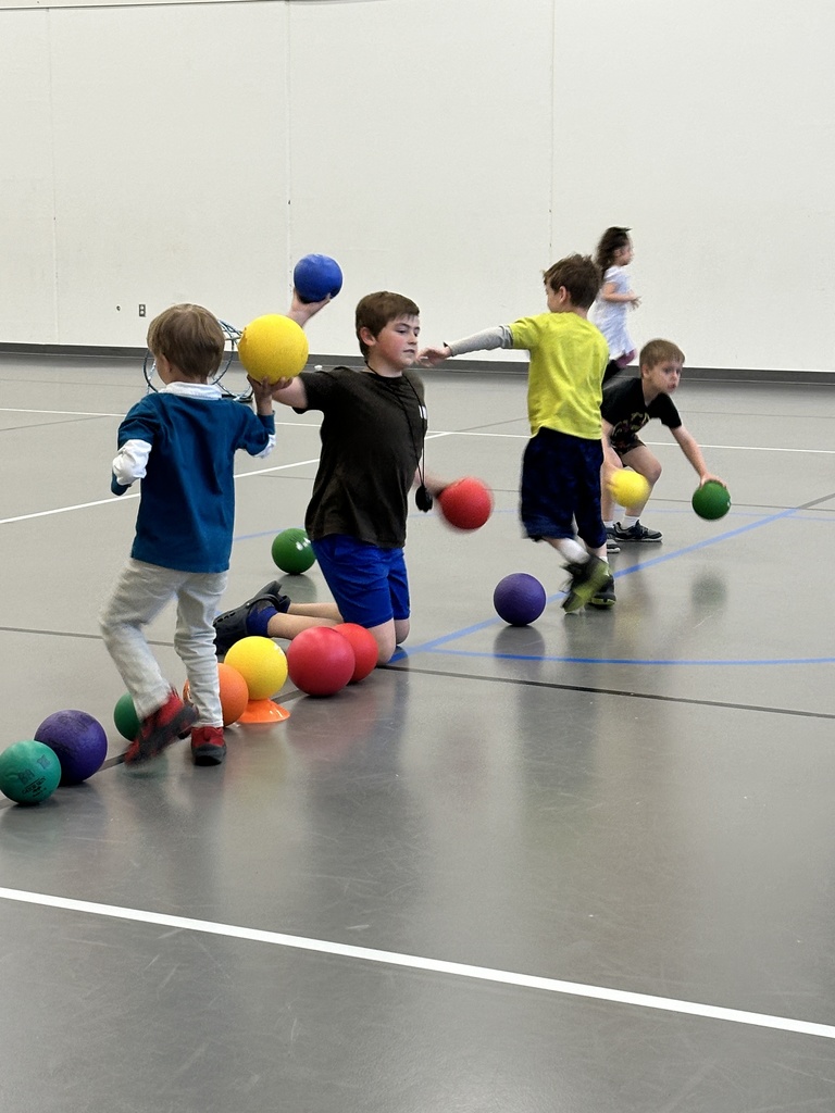 5th grade student helping younger kids in gym class