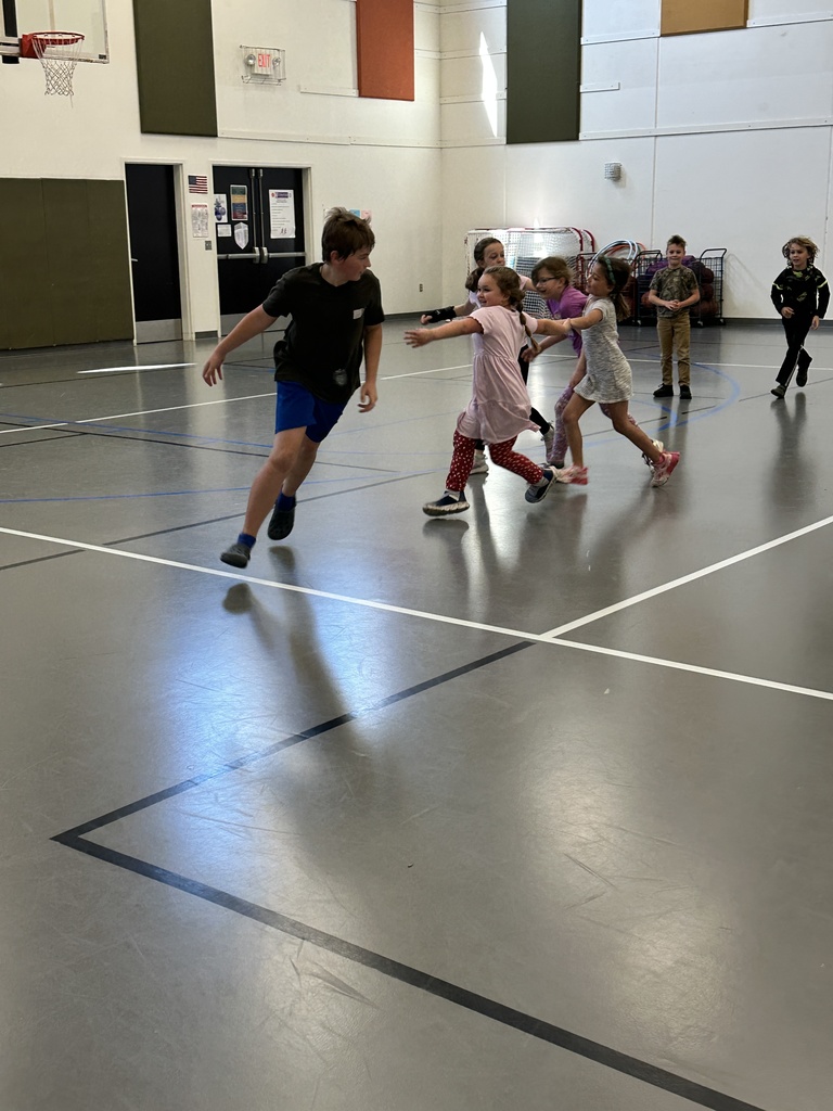 5th grade student helping younger kids in gym class