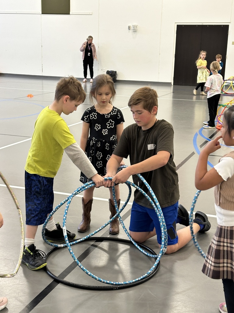 5th grade student helping younger kids in gym class