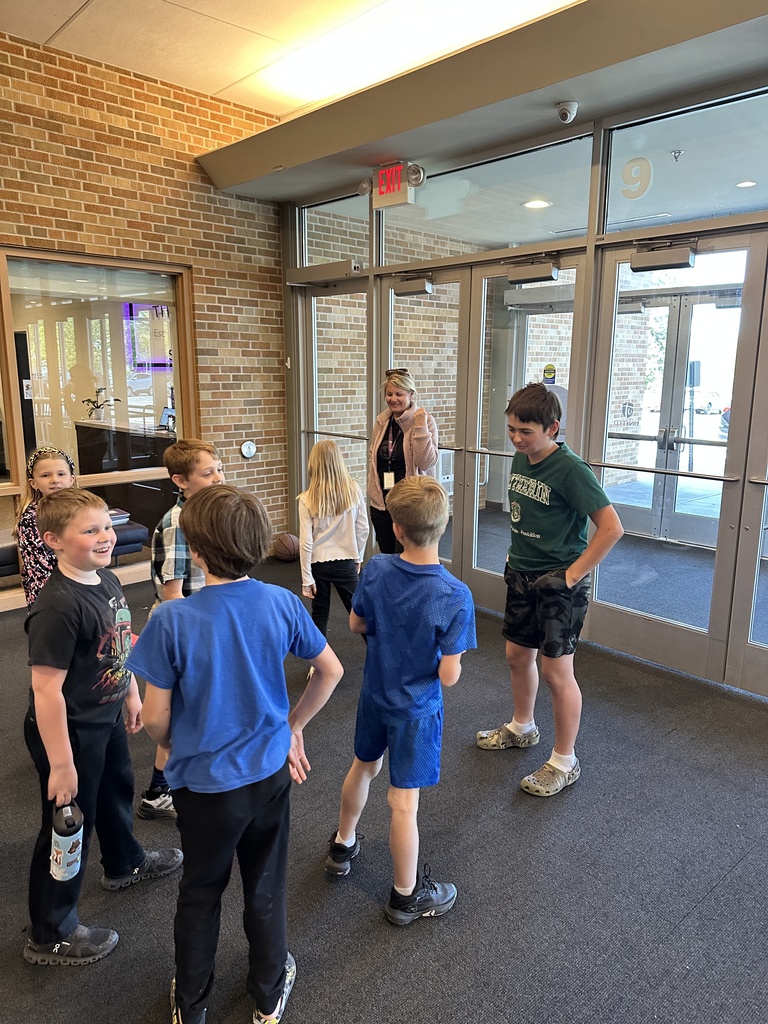 teacher and 6th grade student greeting a group of 3rd grade students
