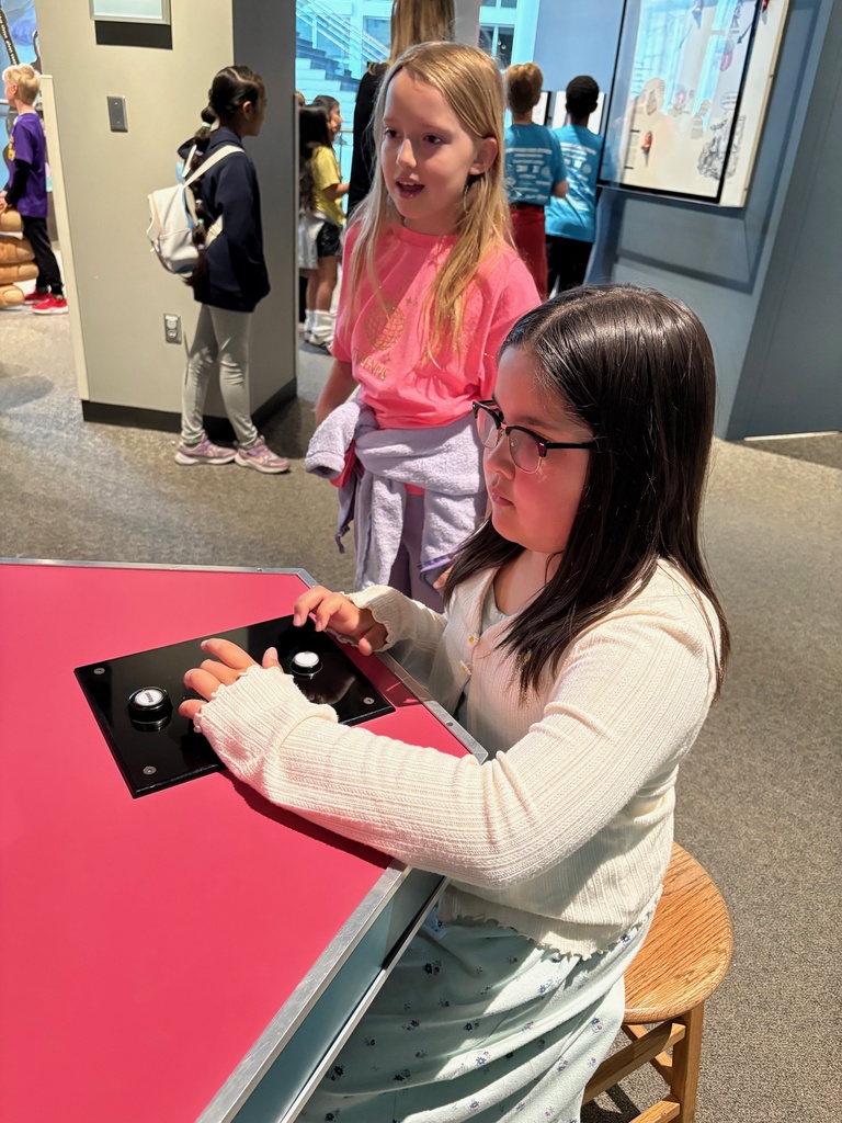 third grade students looking through exhibits at the science museum