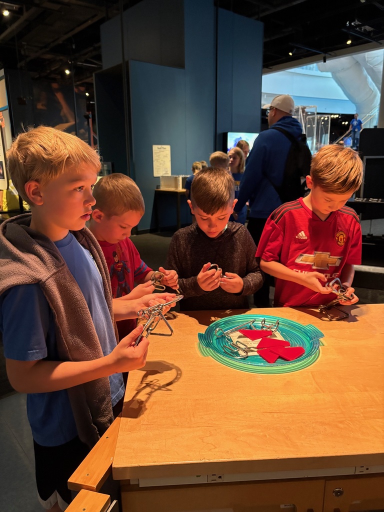 third grade students looking through exhibits at the science museum