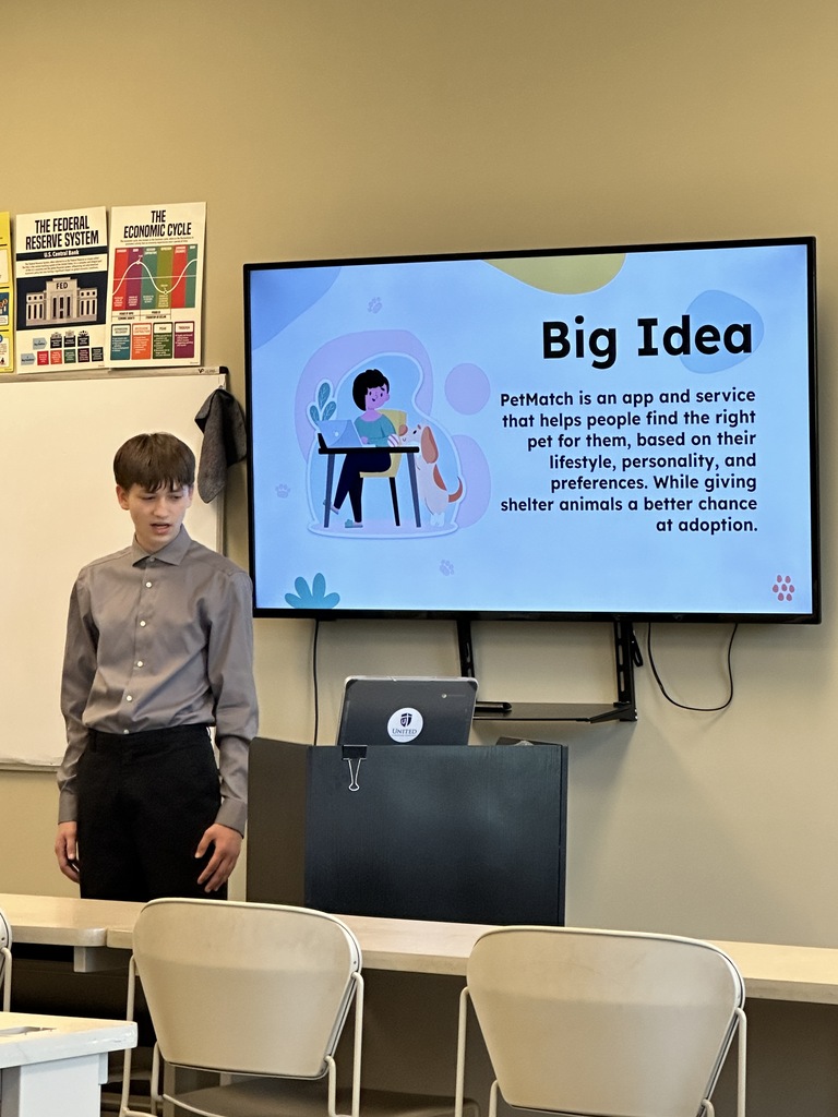 student doing a presentation in the front of a classroom