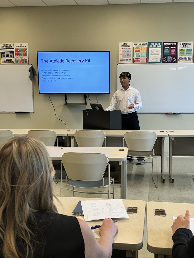 student doing a presentation in the front of a classroom