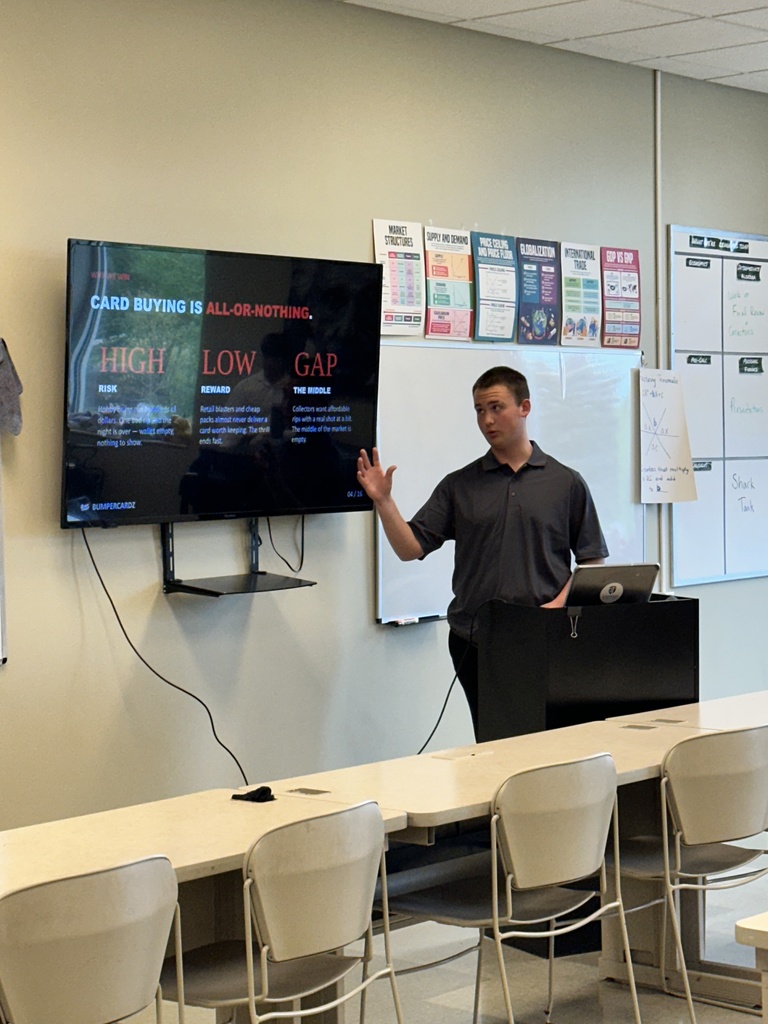 student doing a presentation in the front of a classroom