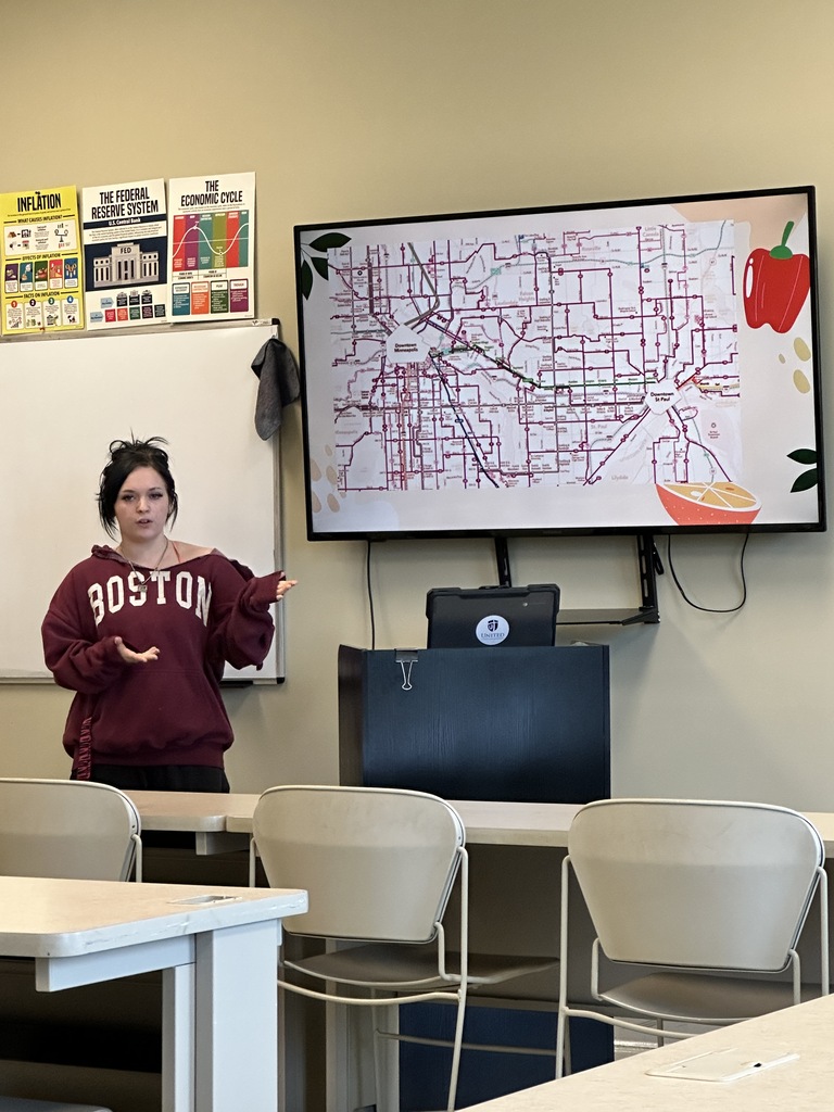 student doing a presentation in the front of a classroom