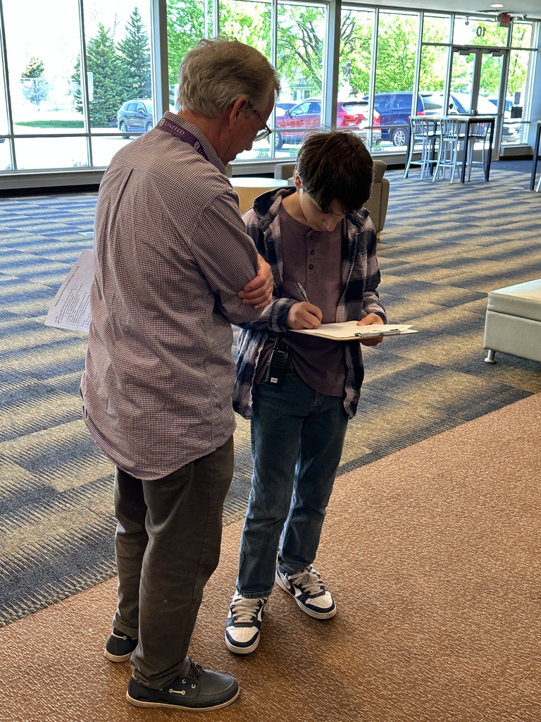 principal and student looking at a clipboard