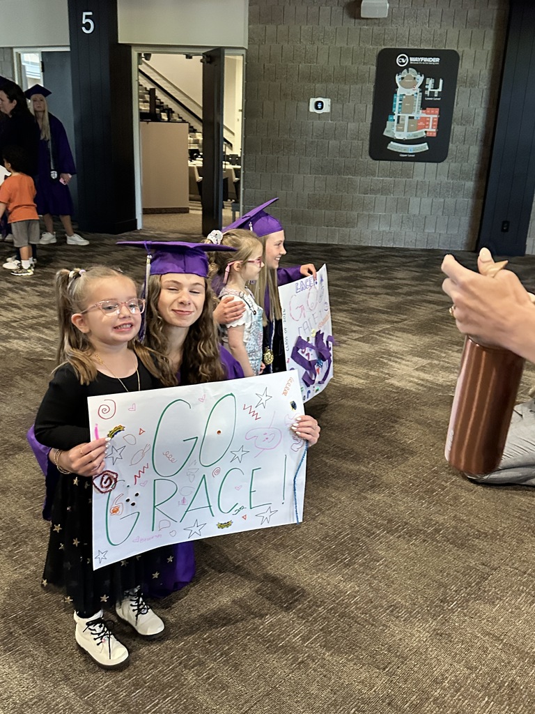 senior in cap and gown with a pre-k student