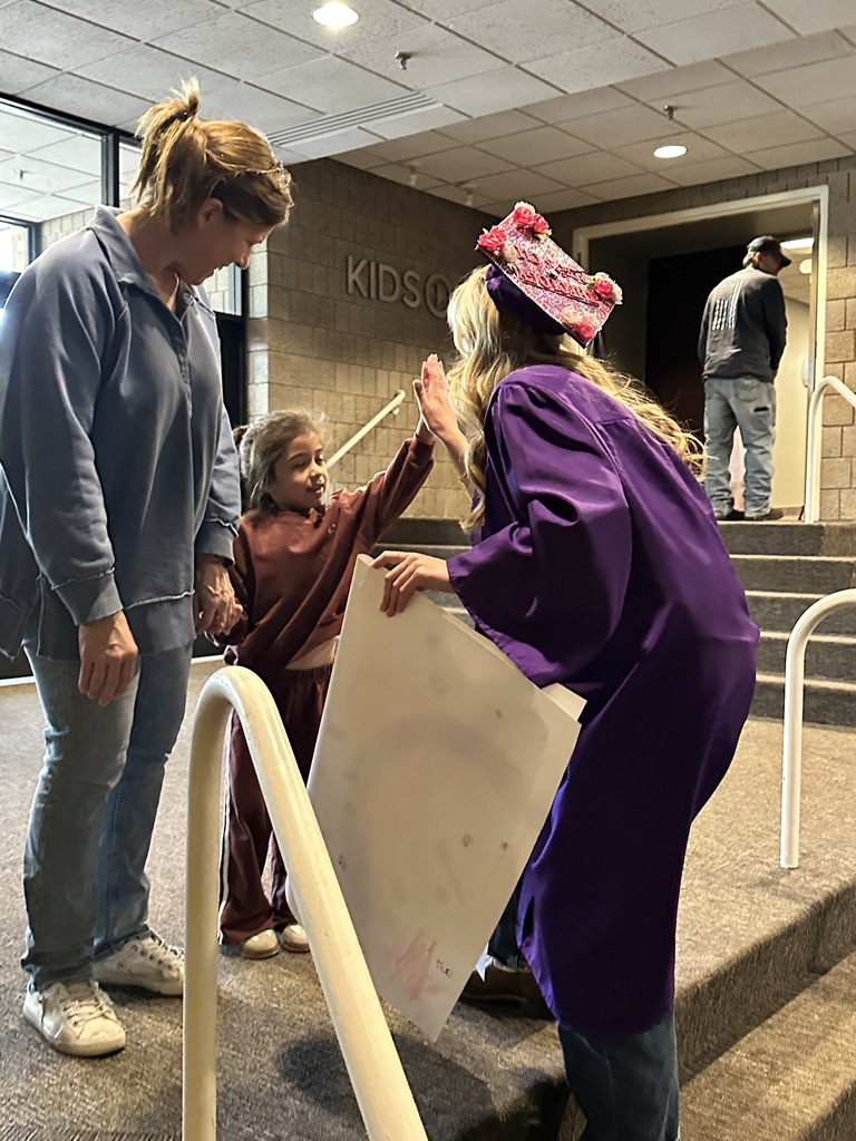 senior in cap and gown with a pre-k student